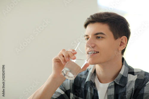 Young man drinking water at...