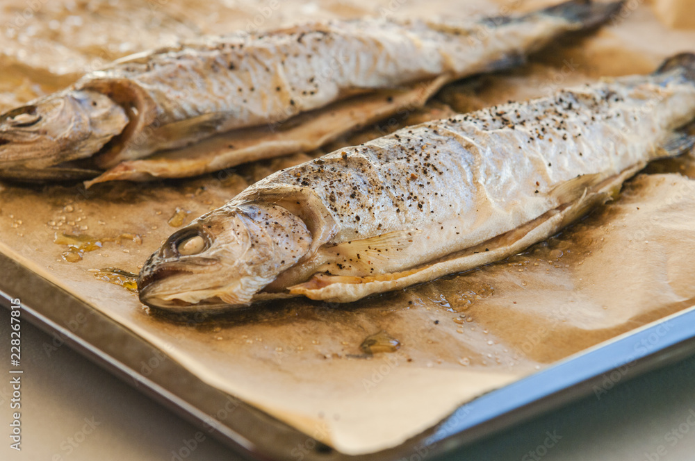 Delicious baked fish on parchment paper, close-up Delicious baked fish on parchment paper, close-up