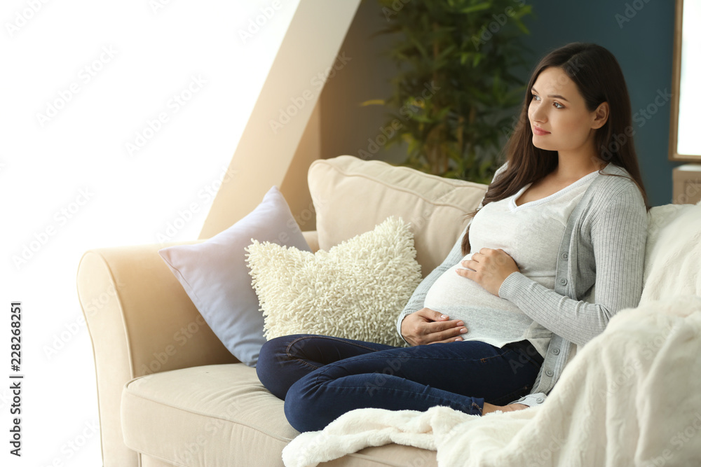 Beautiful pregnant woman resting on sofa at home Beautiful pregnant woman resting on sofa at home