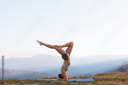 Fotografie Yoga instructor, practicing headstand balance outside in nature