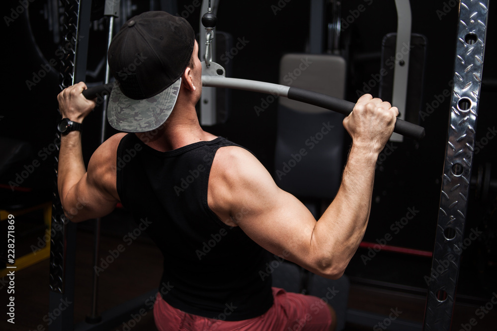 Strong Bodybuilder Doing Heavy Weight Exercise For Back On Machine.