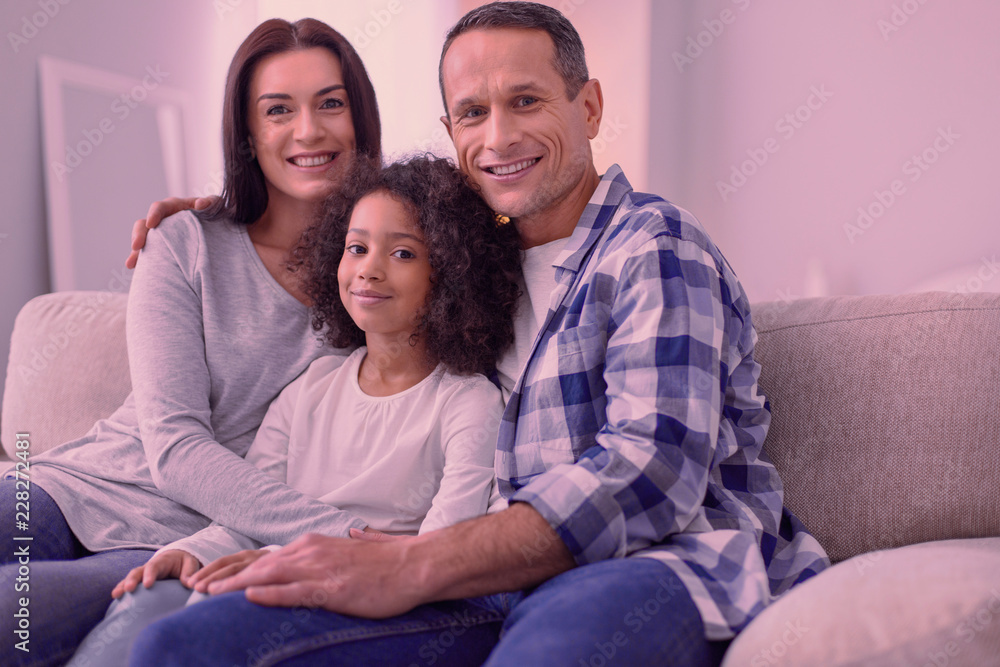 Father and husband. Joyful happy man feeling great while sitting together with his family Father and husband. Joyful happy man feeling great while sitting together with his family