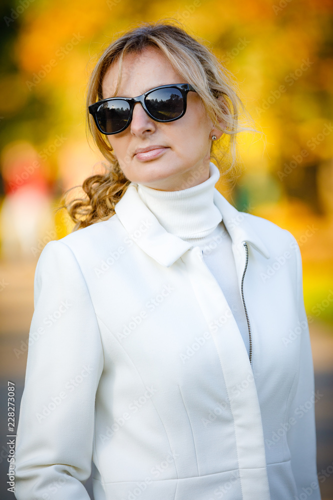 Middle-aged woman walking in city park Middle-aged woman walking in city park