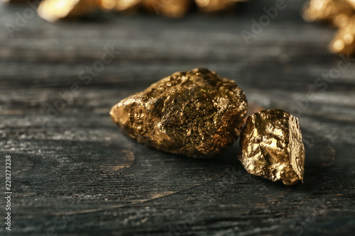 Gold nuggets on dark wooden background