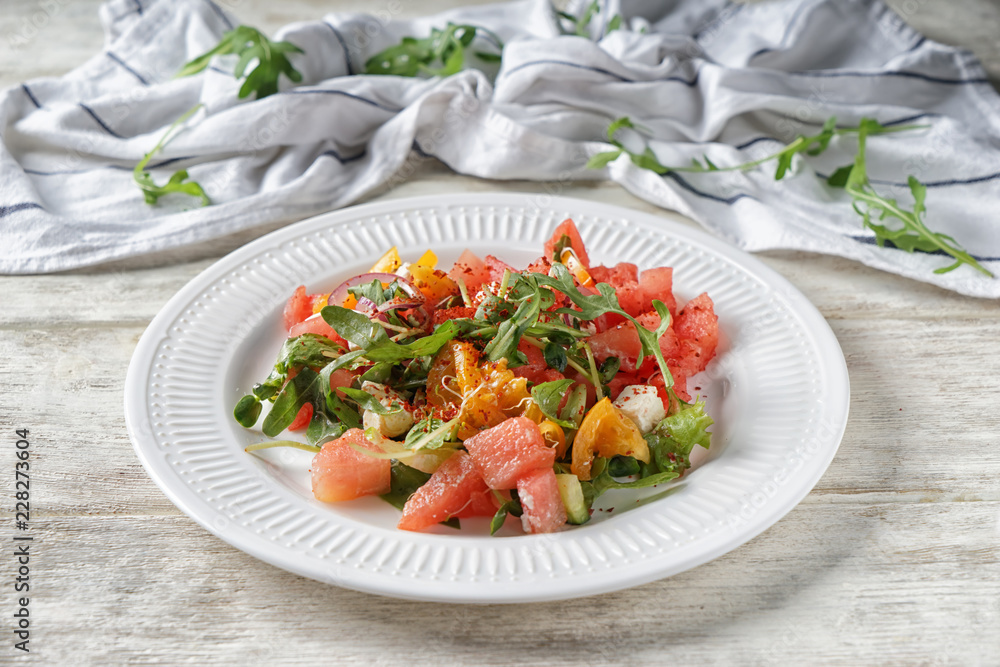 Plate with delicious watermelon salad on white wooden table Plate with delicious watermelon salad on white wooden table