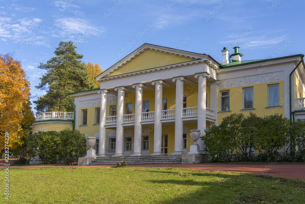 An old two-storey manor house with columns in autumn. Large clearing in front of the house. Gorky Leninskie, Lenin hills, Russia, the last location of Lenin.