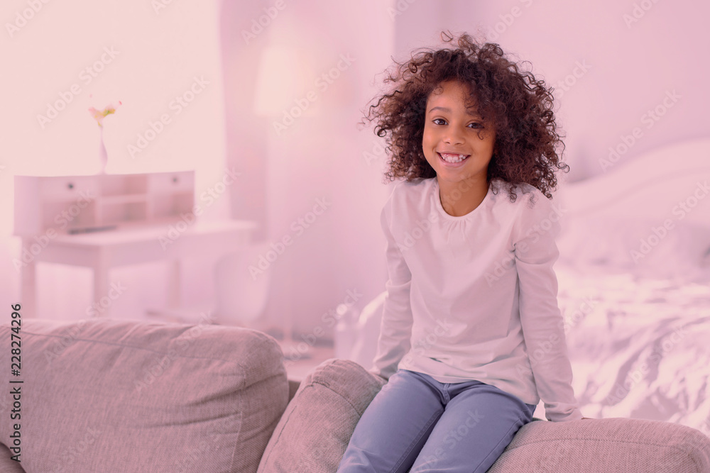 Wonderful day. Joyful pleasant girl smiling to you while resting alone at home Wonderful day. Joyful pleasant girl smiling to you while resting alone at home