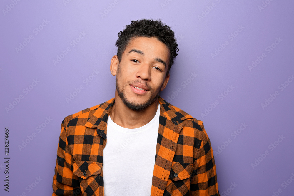 Fototapeta premium Portrait of handsome African-American man on color background