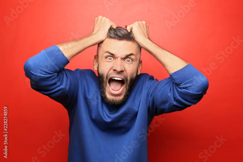 Portrait of aggressive man on color background photo