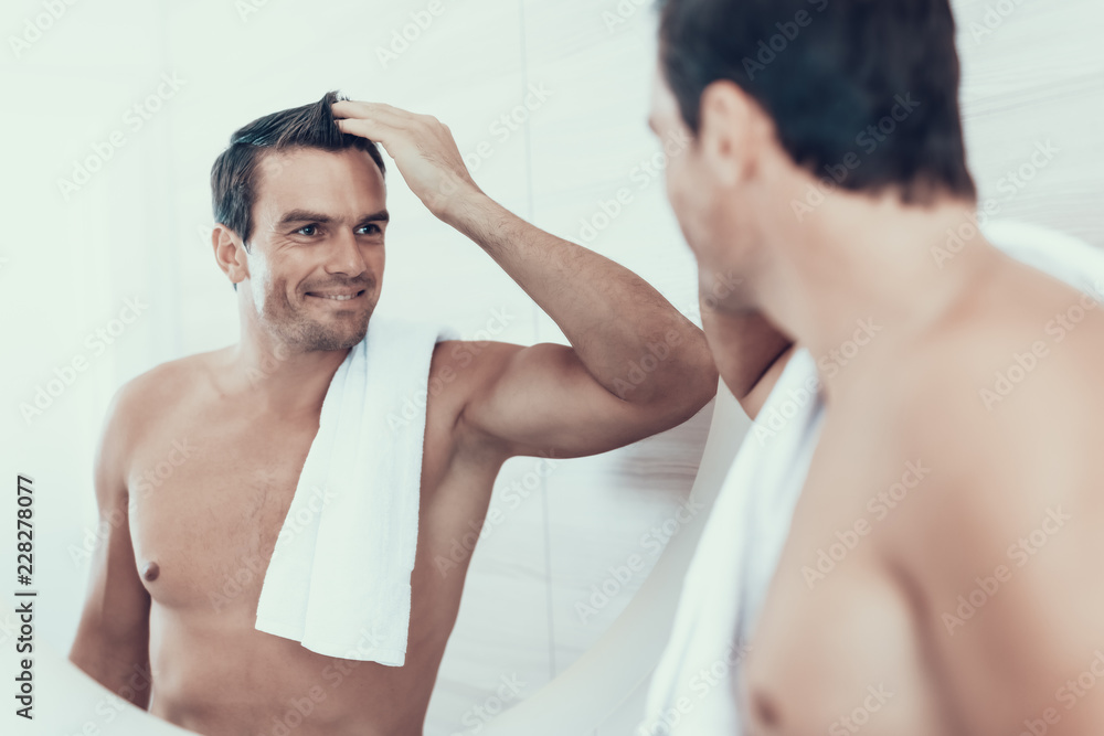 Happy Man in Bathroom Looks at Mirror Reflection Happy Man in Bathroom Looks at Mirror Reflection