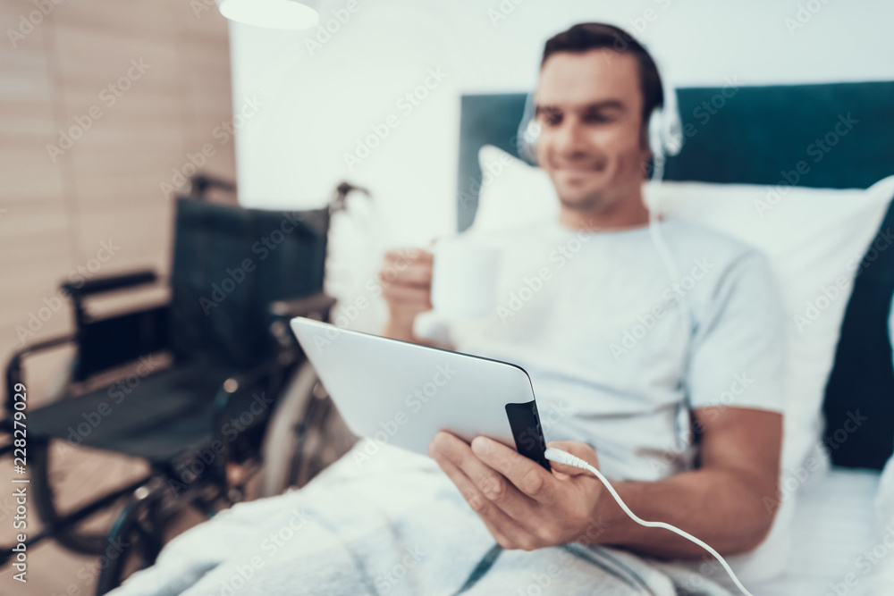Man Watch Video in Pad in Headphones and Hold Cup Man Watch Video in Pad in Headphones and Hold Cup