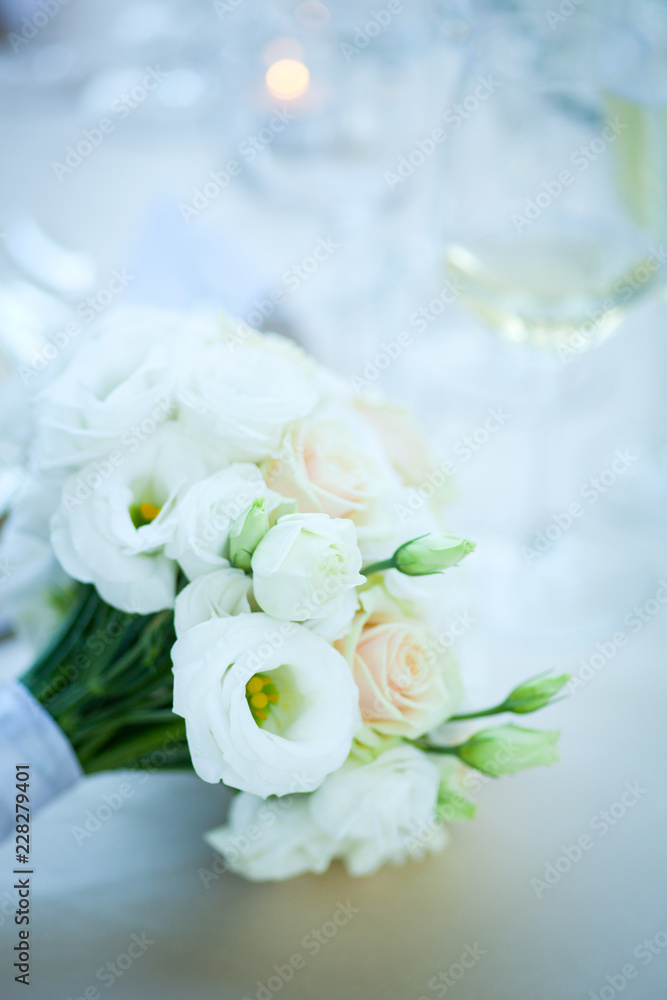 Close up of white flower wedding bouqet o bright romantic set table in natural light Close up of white flower wedding bouqet o bright romantic set table in natural light