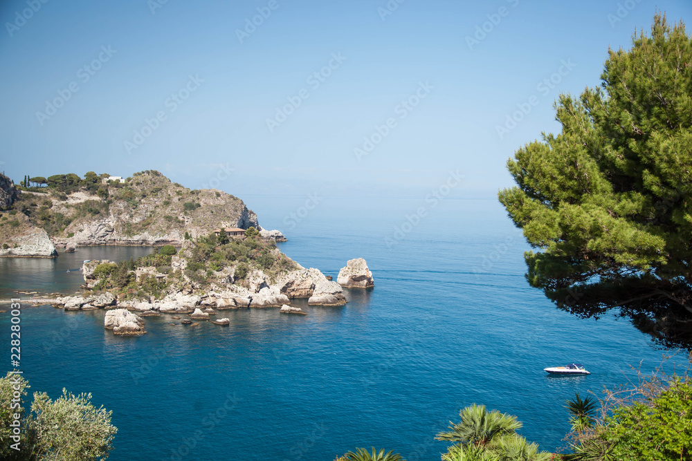 Panoramic view of Isola bella, Taormina, Sicily, Italy, blue sky and water with boats.