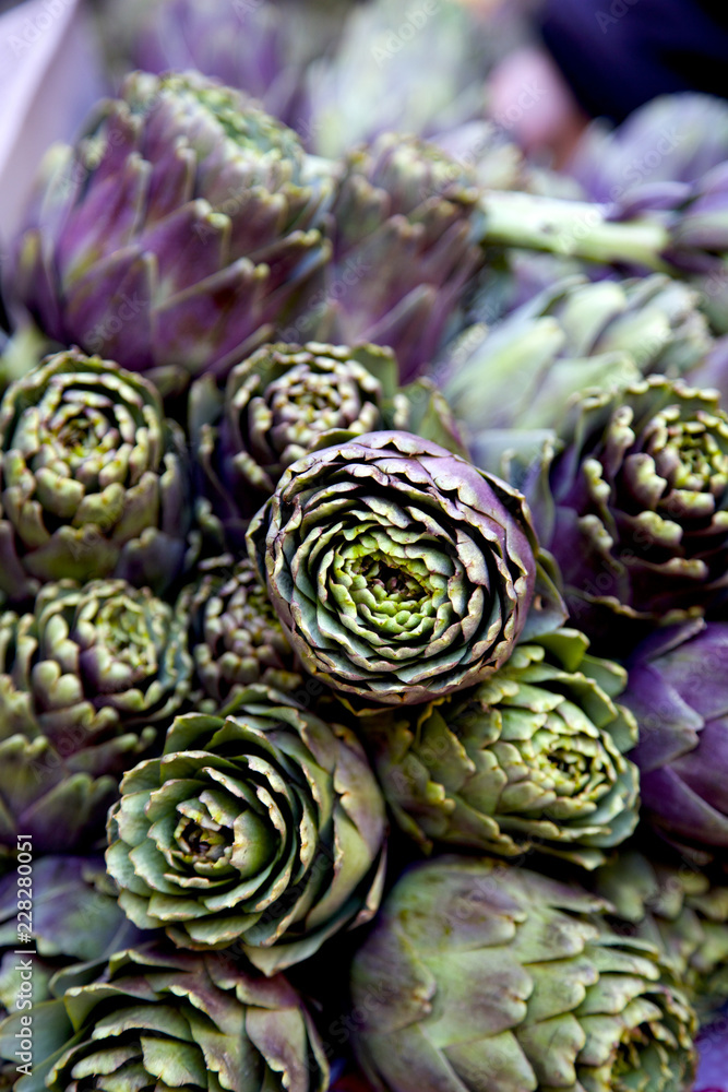 Obraz premium Close up of a mountain of green and purple artichokes.