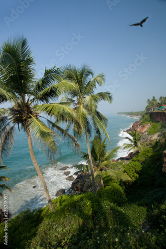 White powdery wide beach in Keral, India, chrystal clear turquoise waters and  cloud free blue sky