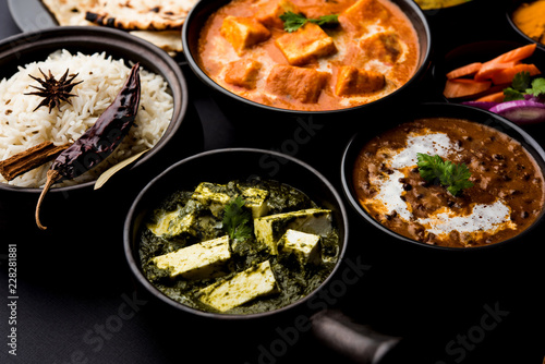 Indian Lunch / Dinner main course food in group includes Paneer Butter Masala, Dal Makhani, Palak Paneer, Roti, Rice etc, Selective focus
