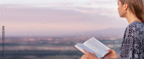 Christian worship and praise. A young woman is reading the bible.