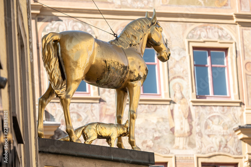 Goldene Pferdeskulptur mit Fuchs vor historische Hausfassade in Ellwangen photo