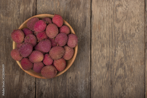 heap of Lychee in wooden plate on wooden background