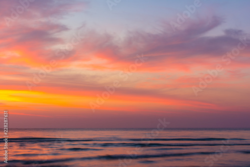 Vivid beautiful sunset and sunrise sky reflection on sea wave.