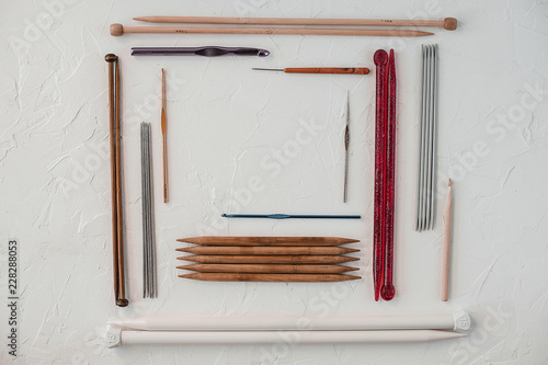 Variety of rochet hooks and knitting needles in different sizes on white background. photo