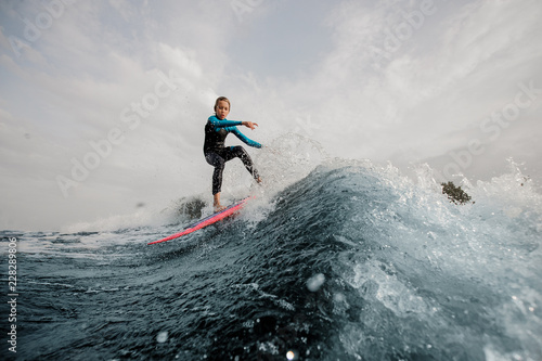 Active teenager jumping on the orange wakeboard