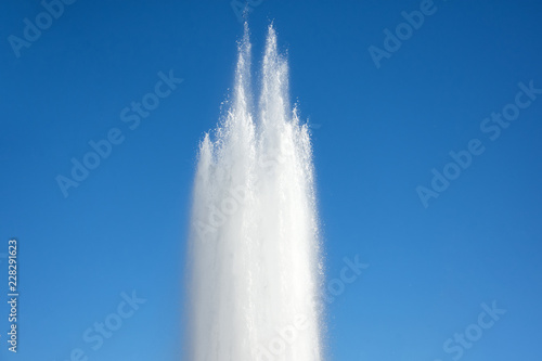 Powerful discharge of water fountain  geyser against the blue sky.