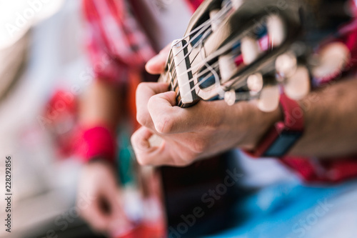 Immerse in music. Close up of attractive male hand pressing strings against fingerboard and composing melody