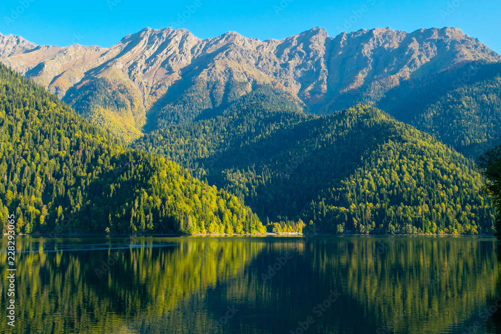 Beautiful mountain lake with green forest hills at the shore. Ritsa Lake, Abkhazia