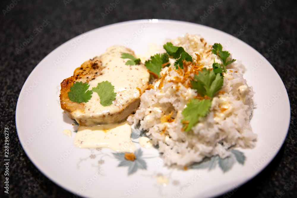 Pork medallion with white jasmine rice, served with fried onion and flat parsley Pork medallion with white jasmine rice, served with fried onion and flat parsley