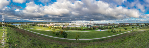 Messestadt Riem Ost in München, Panormaansicjt vom Rodelhügel im Riemer Park bei bewälktem Himmel im Spätsommer