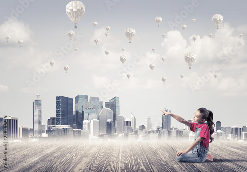 Foto Concept of careless happy childhood with girl pointing at someth