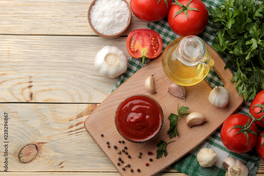 Red sauce in a bowl with fresh ingredients, tomatoes, garlic and oil and spices on a natural wooden table. view from above Red sauce in a bowl with fresh ingredients, tomatoes, garlic and oil and spices on a natural wooden table. view from above