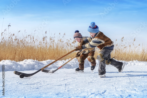 Boys play hockey on a frozen lake photo