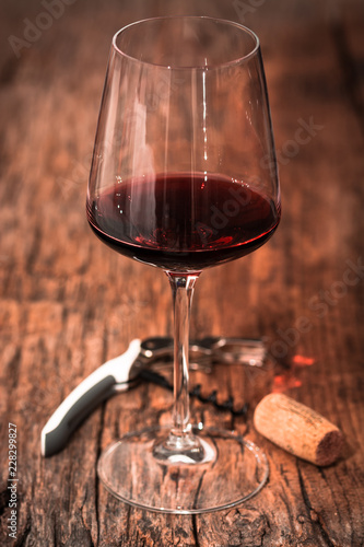 calice di vino rosso su tavolo di legno con cavatappi e tappo di sughero