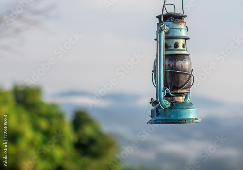 vintage kerosene lantern on nature blur background.