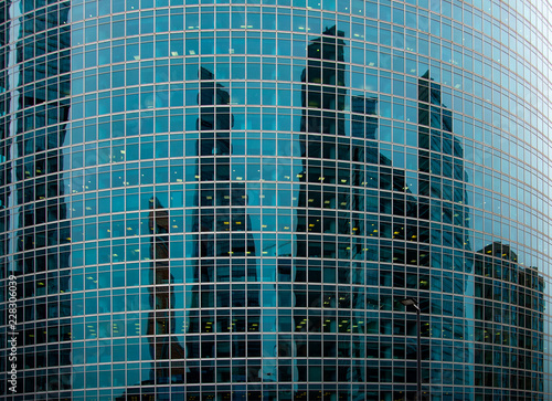 The buildings of the business center of Moscow City are reflected in the facade of the tower on the embankment