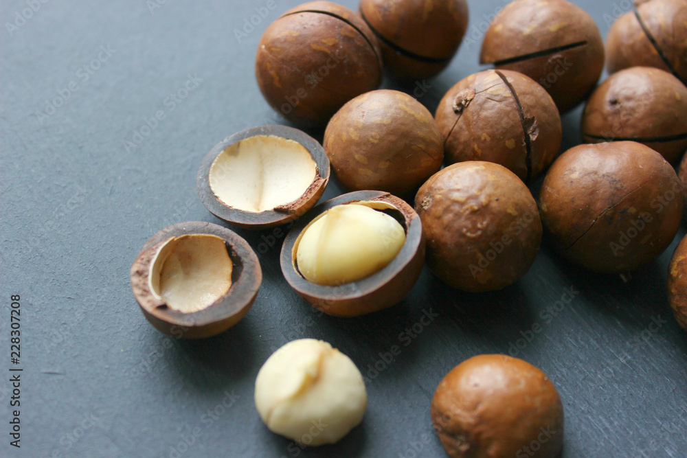 Obraz premium Macadamia nuts on a wooden table close-up. Healthy food, healthy lifestyle, diet, vegetarianism.