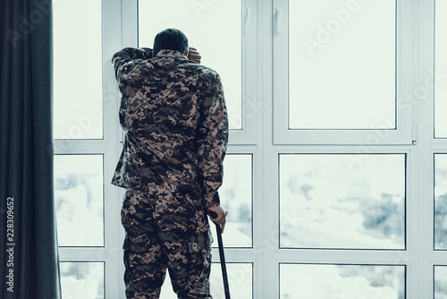 Foto Back view of Soldier Leaning on Crutch By Window