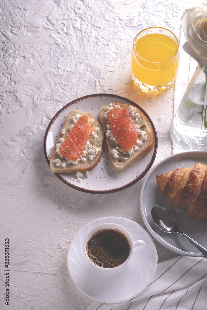 Continental breakfast captured from above (top view, flat lay). Coffee, orange juice, croissant, sandwich and flowers. Copy space. Continental breakfast captured from above (top view, flat lay). Coffee, orange juice, croissant, sandwich and flowers. Copy space.