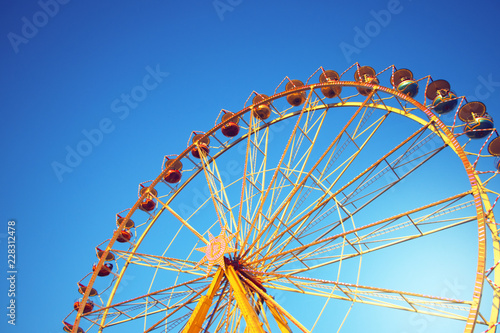 colorful ferris wheel with blue sky and copy space