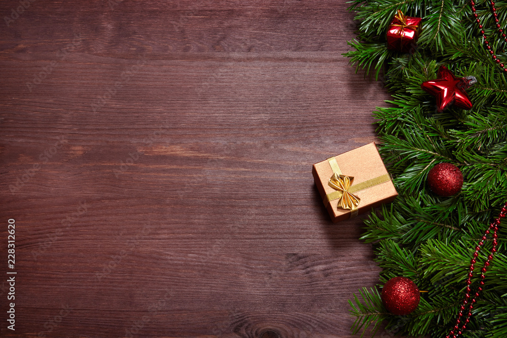Fototapeta premium Christmas decorations, spruce branches and gifts on wooden surface.