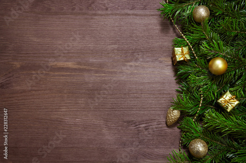 Christmas decorations, spruce branches and gifts on wooden surface.