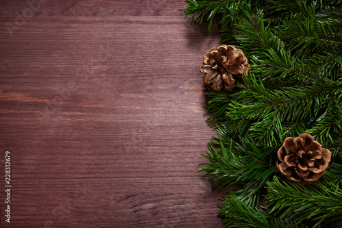  Christmas tree branches and pine cones on wooden background. 
