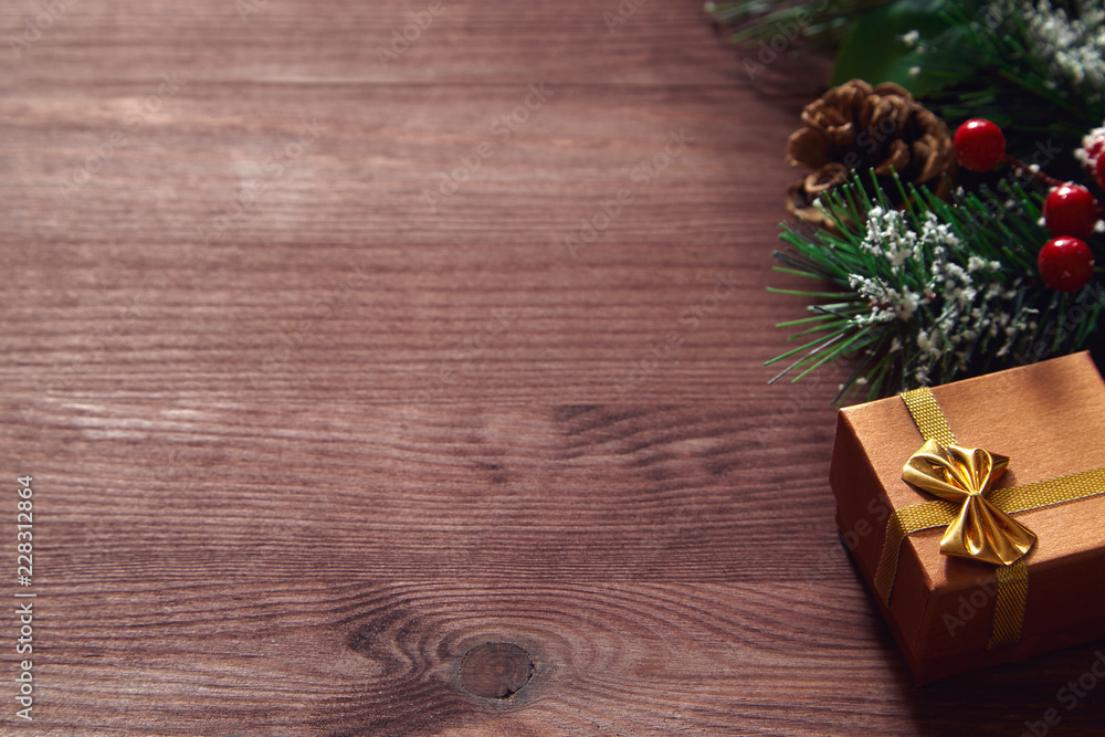 Fir tree branches, red berries and present box on wooden surface. Christmas and new year background. Fir tree branches, red berries and present box on wooden surface. Christmas and new year background.