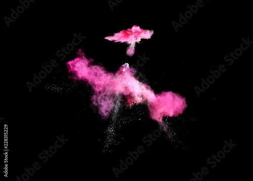 Colorful explosions of powder paint and flour combined together explode in front of a black background to give off fantastic multi colored cloud forms.