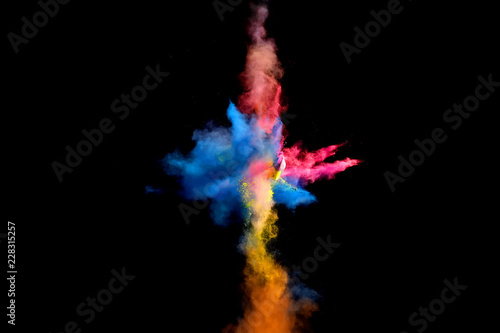 Colorful explosions of powder paint and flour combined together explode in front of a black background to give off fantastic multi colored cloud forms.