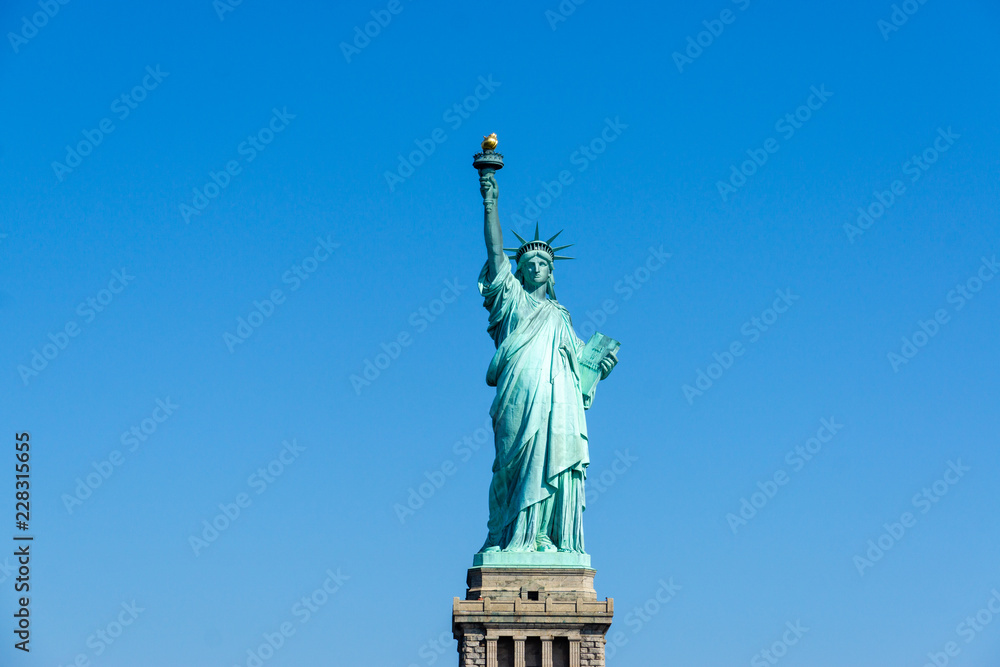 Fototapeta premium The Statue of Liberty in New York City isolated on on a blue sky background