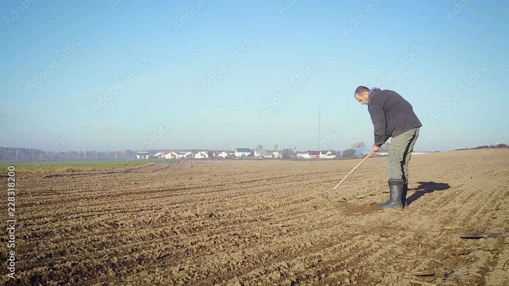 The farmer handles the land with a hoe