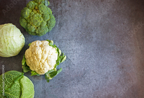 Four types of cabbage on a dark background: white, Savoy, cauliflower, broccoli